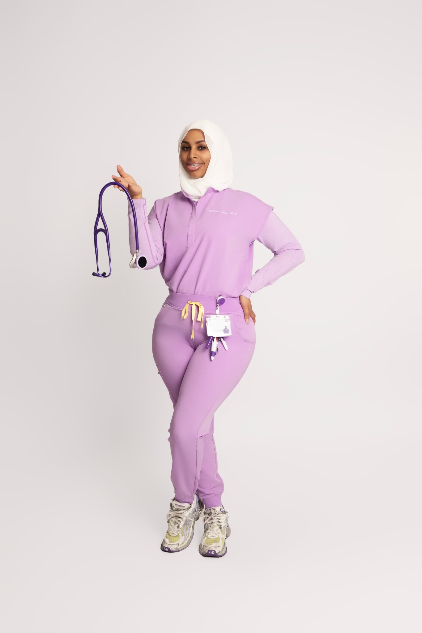 Ny’Rossha Alim in purple scrubs holding a stethoscope
